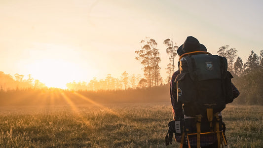 21 Best Travel Gifts for Explorers - ethical travel gift ideas - traveller looks out over sunrise with backpack on their back