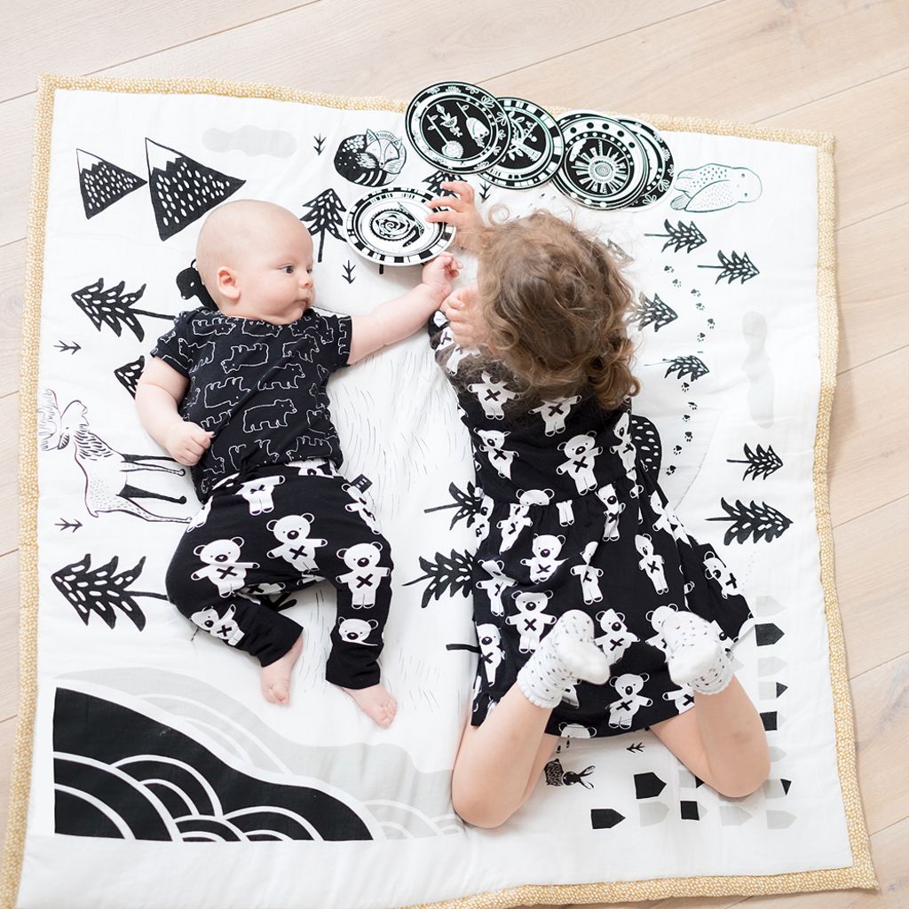 Children lying on Wee Gallery Playmat - Explore in Organic Cotton