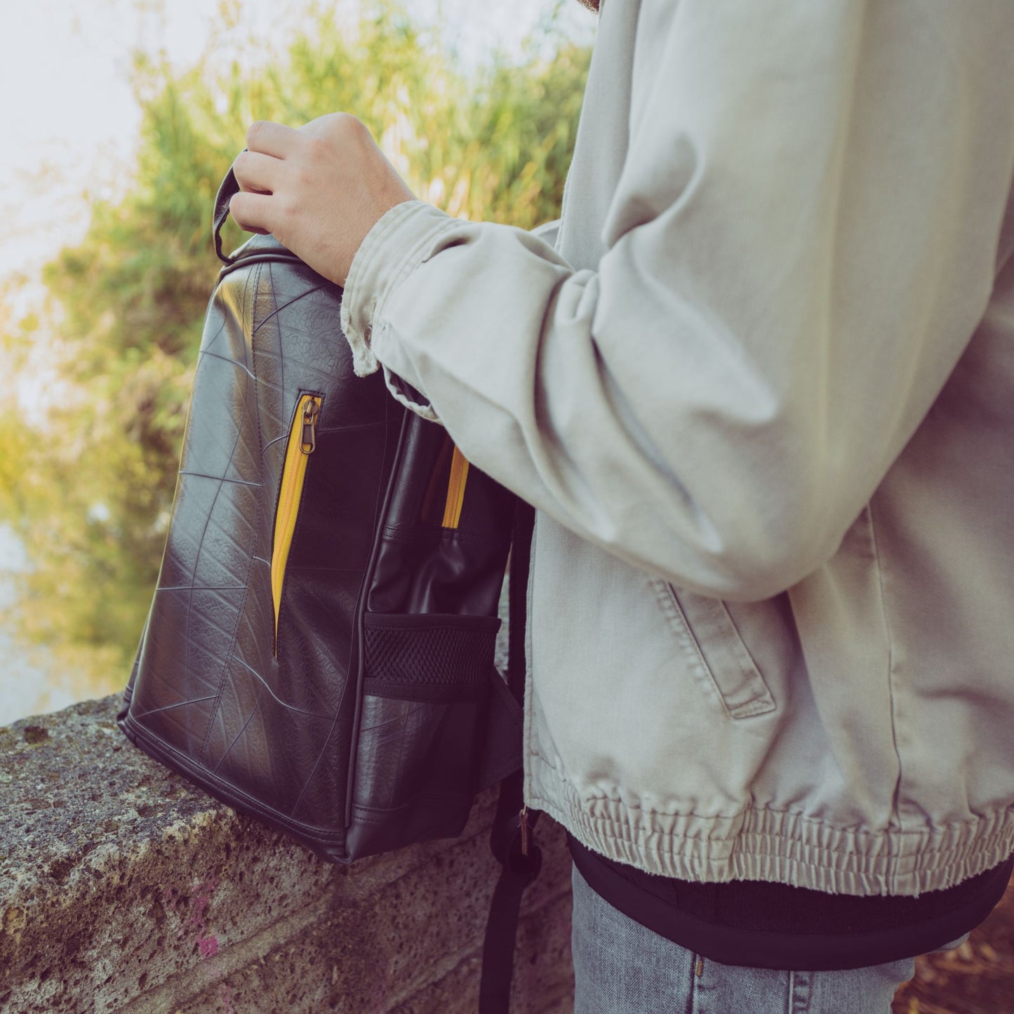 Hackney Backpack made from Recycled Materials - person opening sustainable backpack