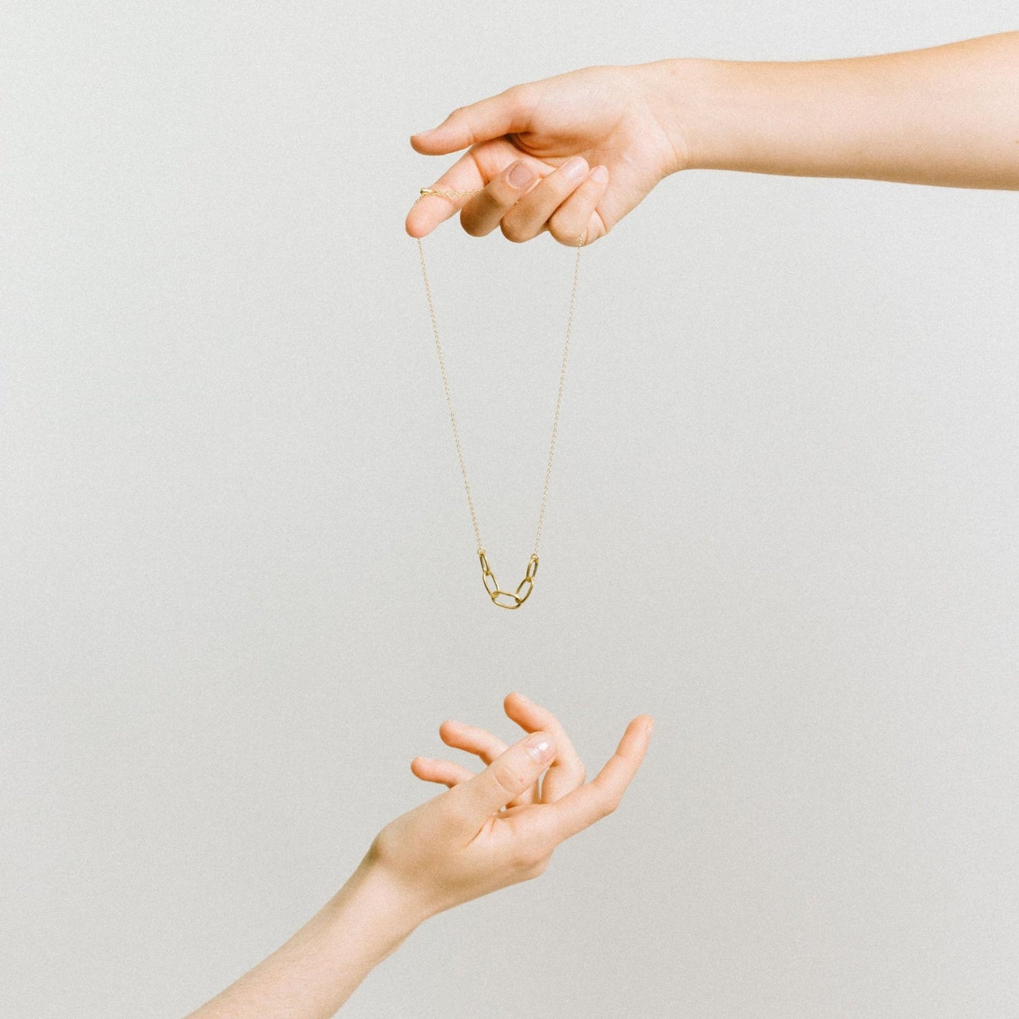 Infinite Necklace  Empowering Women in Uganda - brass chain necklace - between hands