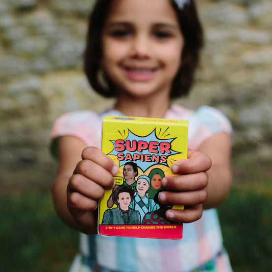 Super Sapiens  A 3-in-1 Game to Help Change the World - Ava holding the card game